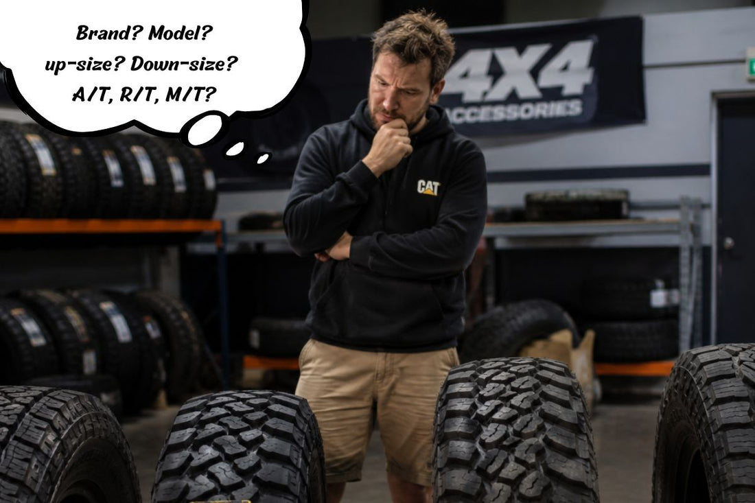 Man standing in garage thinking over what 4x4 tyres to use.