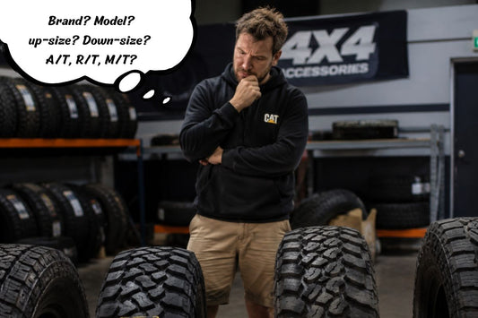 Man standing in garage thinking over what 4x4 tyres to use.