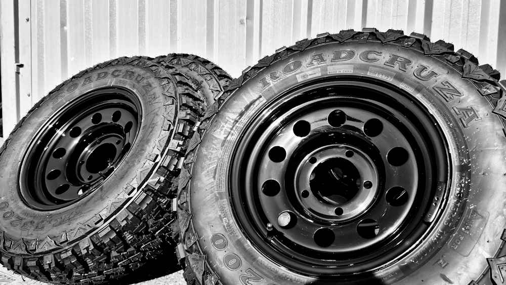 black and white image of Roadcruza tyres mounted on Gojos black Modulars leaning against wall.